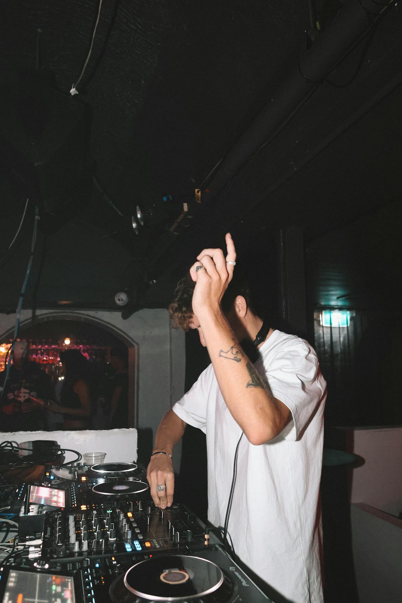 Energetic DJ spinning tracks in a lively club with flashing lights and a vibrant crowd.